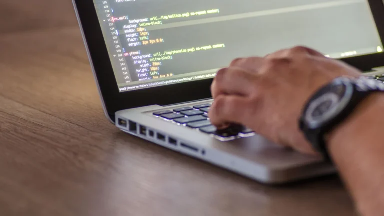 Dirigeante vérifiant les accès de son site avec un développeur web devant un ordinateur